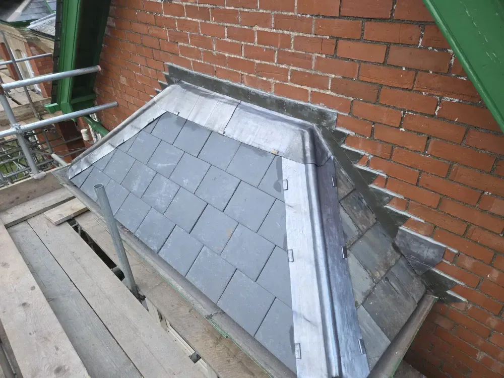 Slated dormer roof finished with lead soakers and stepped flashing to the brickwork